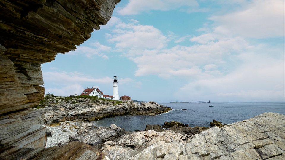 Portland Head Light seen through a rocky coastal opening in Cape Elizabeth, Maine
